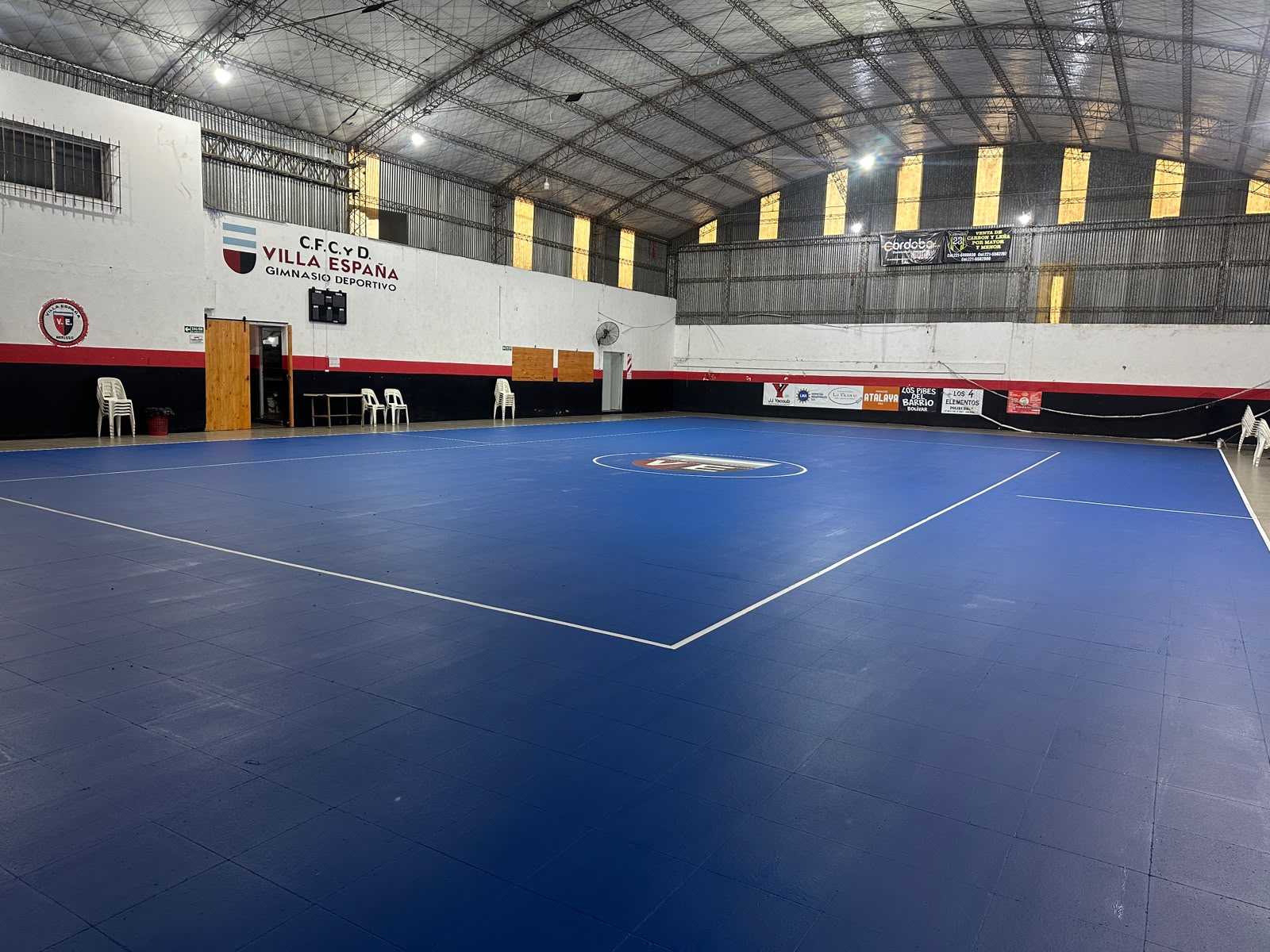 Después: la misma cancha cubierta pintada de azul, con líneas blancas.